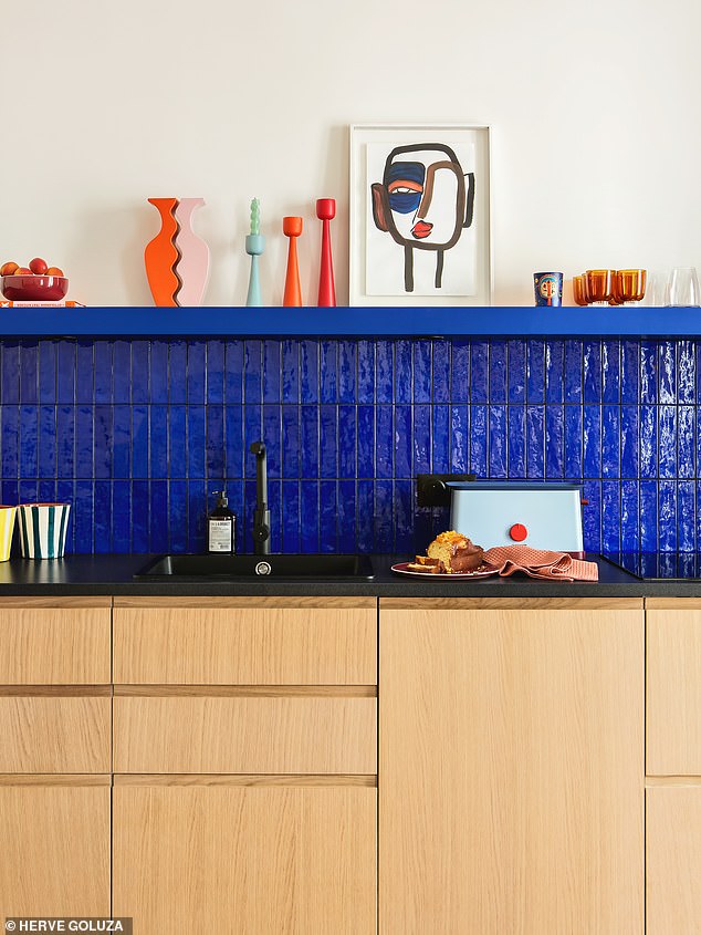 Here, the timber kitchen cupboards by plum-living.com accent the vibrancy of the blue, achieving a calm balance. For similar dining tables, see oka.com